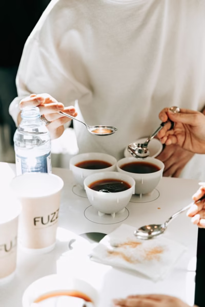 hands with teaspoons over coffee on table